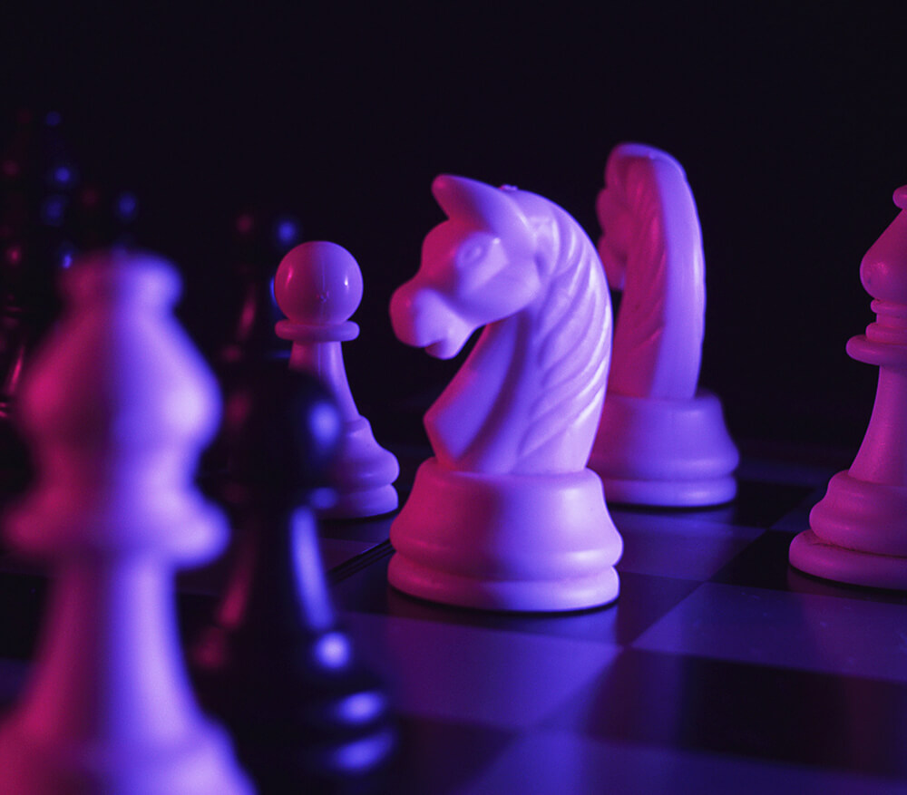 Close up of chess pieces in purple lighting